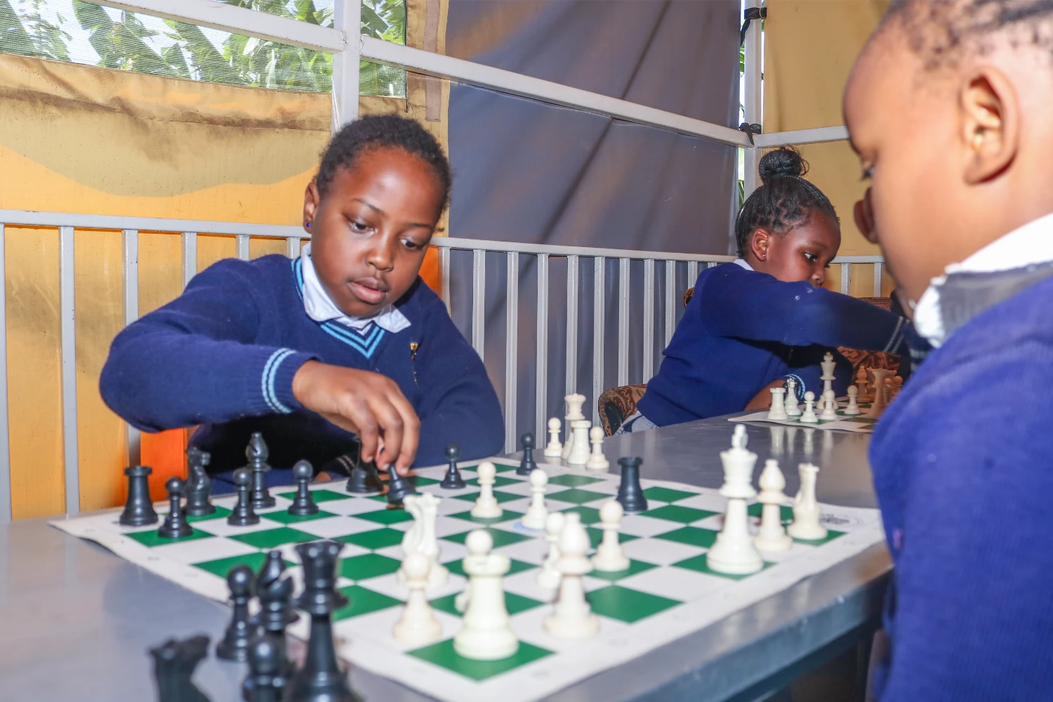 A Primary pupil moving a piece during a chess game at St. Christopher's